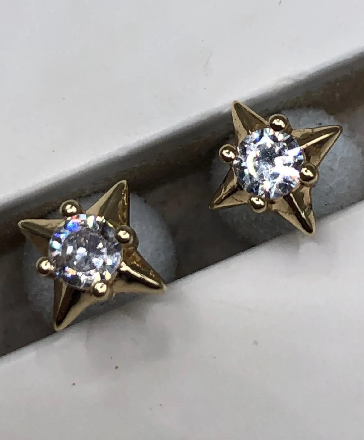 Brinco Ban dourado Estrela com Pedra Branca